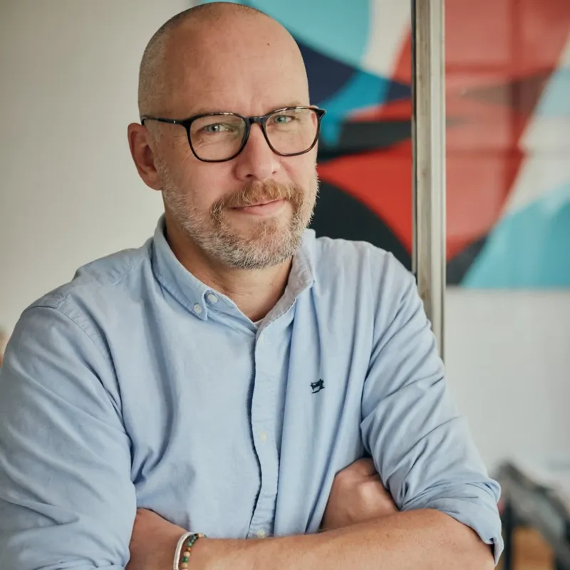 Thomas Voigt lehnt an einen Türrahmen und schaut lässig in die Kamera